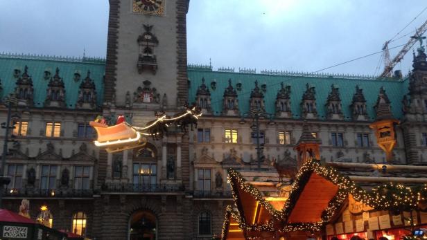 Wer fliegt denn da? Der Weihnachstmann in der Rentier-Kutsche hoch über dem Rathausmarkt