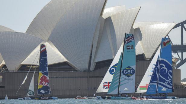 Mehrere Segelboote fahren vor dem Opernhaus von Sydney.