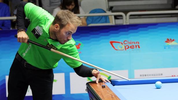 Ein Billardspieler zielt auf eine Kugel beim China Open Turnier.