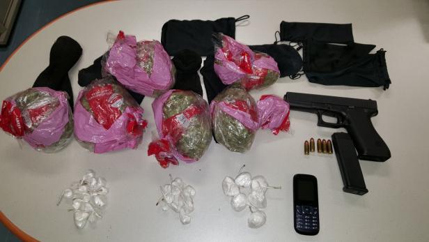 Beschlagnahmte Gegenstände, darunter eine Schusswaffe, Munition, Drogen und Sturmhauben.