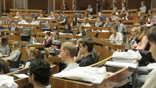 Ein voll besetzter Hörsaal mit Studierenden während einer Vorlesung.