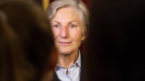 Das Porträt einer Frau mit hellgrauen Haaren und blauen Augen.