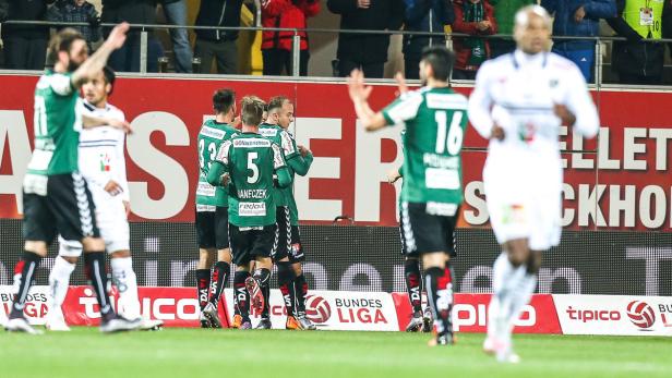 Fußballspieler jubeln auf dem Spielfeld während eines Bundesligaspiels.