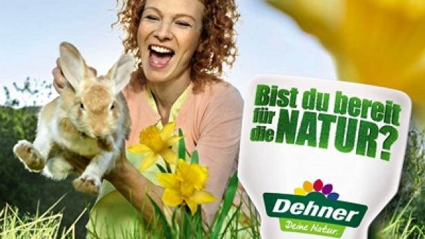 Eine lachende Frau hält ein Kaninchen in der Hand, daneben Narzissen und ein Dehner-Logo.
