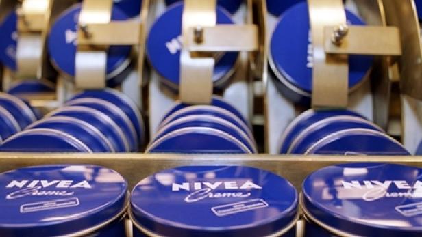 Mehrere blaue Nivea Creme Dosen auf einem Förderband.