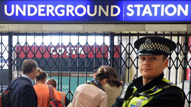Ein Polizist steht vor dem Eingang einer U-Bahn-Station.