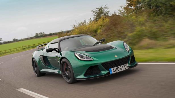 Ein grüner Lotus Sportwagen fährt auf einer Landstraße.