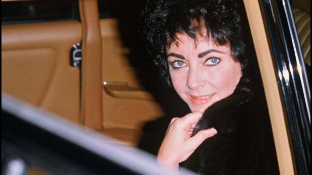 Elizabeth Taylor schaut aus dem Fenster eines Autos.