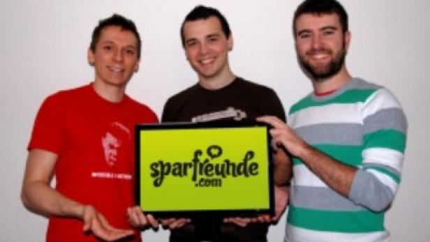 Drei Männer halten einen Bildschirm mit dem Logo von „sparfreunde.com“.