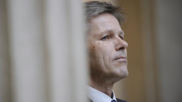 Ein Mann mit grauen Haaren blickt nach oben.