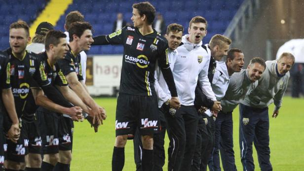 Eine Reihe von Fußballspielern und Trainern des SCRA hält Händchen.