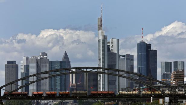 Ein Güterzug fährt über eine Brücke vor der Skyline von Frankfurt am Main.