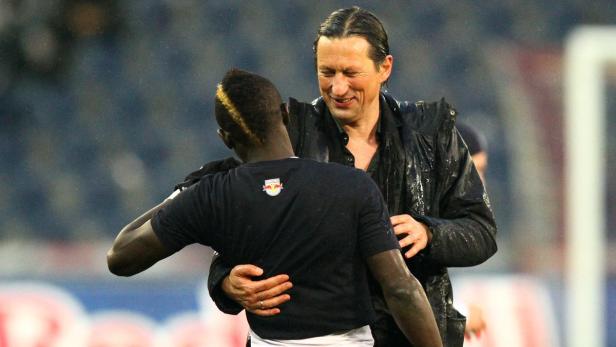 Ein Fußballspieler umarmt seinen Trainer im Regen.