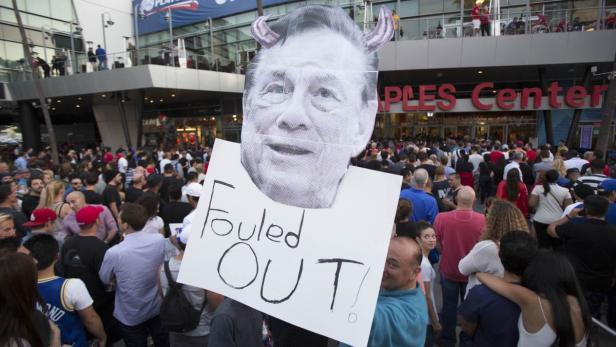 Eine Menschenmenge vor dem Staples Center, im Vordergrund ein Schild mit der Aufschrift „Fouled Out!“ und dem Gesicht einer Person mit Teufelshörnern.