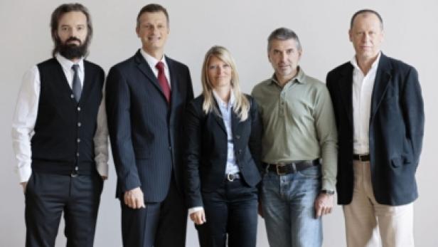 Fünf Personen stehen nebeneinander vor einem hellen Hintergrund.
