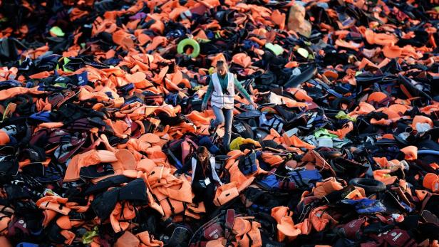 Lesbos: Freiwillige gehen auf einem riesigen Haufen aus Schwimmwesten (Archiv)