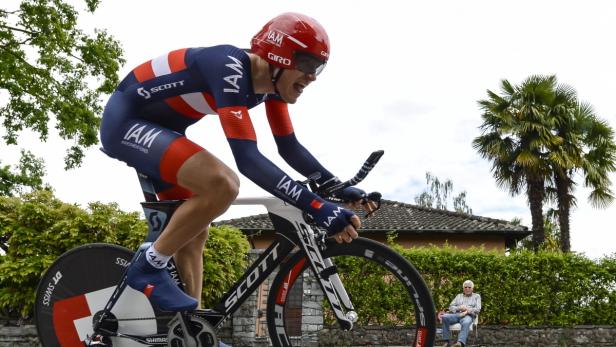 Ein Radrennfahrer in roter und blauer Sportkleidung fährt ein Scott-Fahrrad.