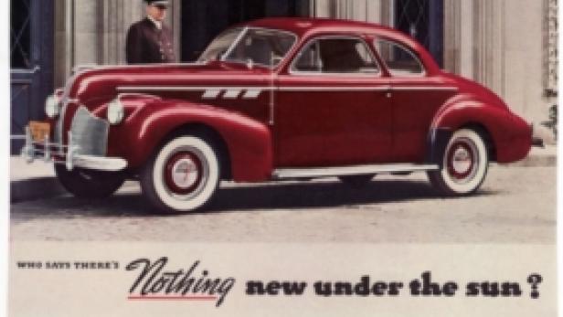 Ein roter Pontiac „Torpedo Coupe“ parkt vor einem Gebäude mit einem Chauffeur.