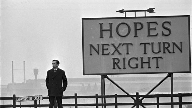 Ein Mann steht neben einem Schild mit der Aufschrift „Hopes Next Turn Right“ an der Bilston Road.