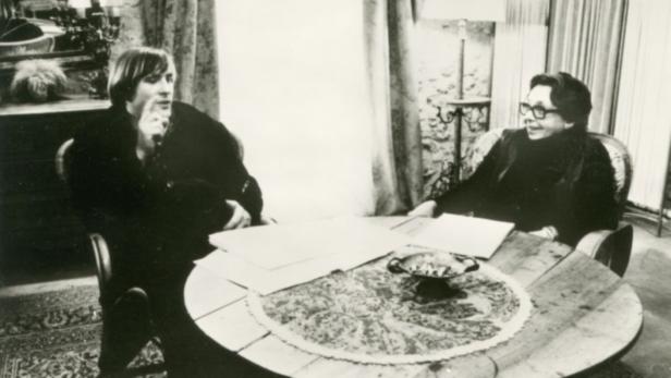 Ein Mann und eine Frau sitzen an einem Tisch und unterhalten sich.