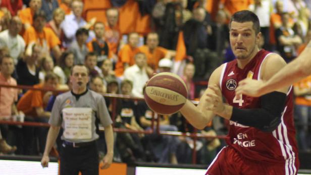Ein Basketballspieler mit der Nummer 4 dribbelt den Ball während eines Spiels.