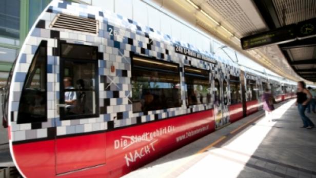 Eine U-Bahn der Wiener Linien mit der Aufschrift „Die Stadt gehört Dir. Nacht“ steht an einem Bahnsteig.