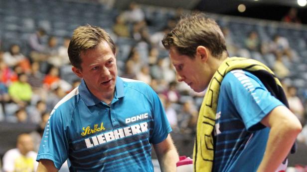 Ein Trainer spricht mit einem Tischtennisspieler während eines Spiels.