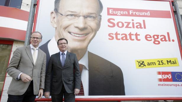 Zwei Männer stehen vor einem Wahlplakat von Eugen Freund (SPÖ) mit dem Slogan „Sozial statt egal“.