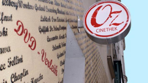Das Schild der „Oz Cinemathek“ hängt an einer Wand mit DVD-Verleih-Aufschriften.