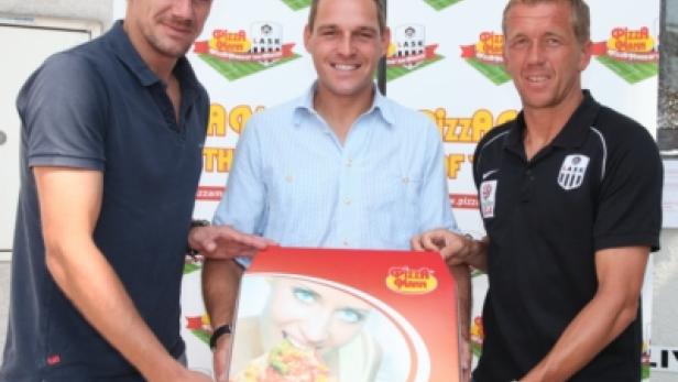 Drei Männer halten eine Pizza-Harn-Box mit dem LASK-Logo.