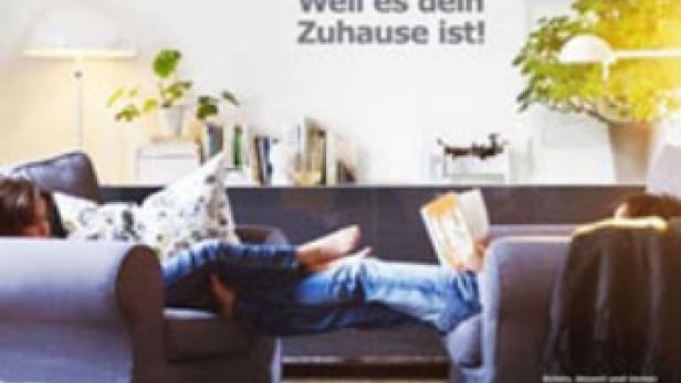 Ein Mann liest entspannt auf einem grauen Sofa in einem Wohnzimmer mit IKEA-Möbeln.