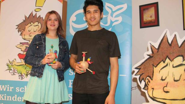 Julia Rotter (16) und Mahdi Sharifa (12) zwei der fünf Preisträger_innen mit ihren spielerisch-verspielten Holz-Trophäen