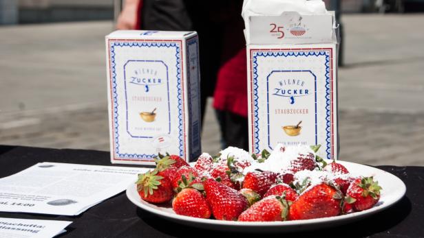 Ein Teller Erdbeeren, bestäubt mit Staubzucker der Marke „Wiener Zucker“.