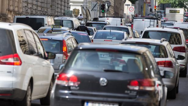 Dichter Verkehr mit vielen Autos und Lieferwagen auf einer Straße.