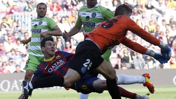 Lionel Messi wird während eines Fußballspiels von einem Torwart angegriffen.