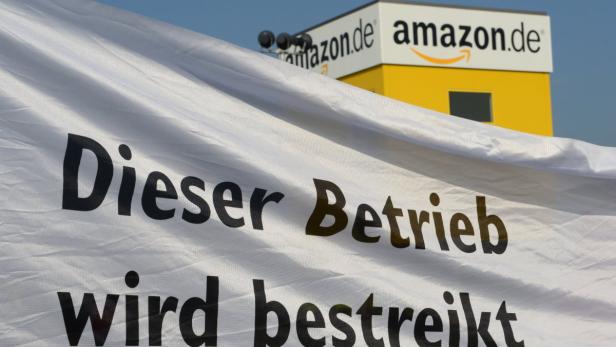 Ein Transparent mit der Aufschrift „Dieser Betrieb wird bestreikt“ vor einem Amazon-Gebäude.