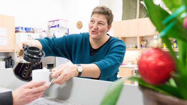 Eine Frau schenkt Kaffee in eine Tasse ein.