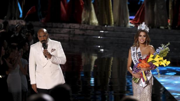 Steve Harvey moderiert die Miss Universe Wahl, bei der die Gewinnerin eine Krone und einen Blumenstrauß erhält.
