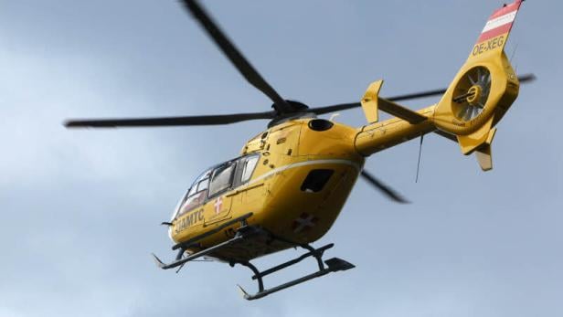 Ein gelber Rettungshubschrauber des ÖAMTC ist in der Luft.