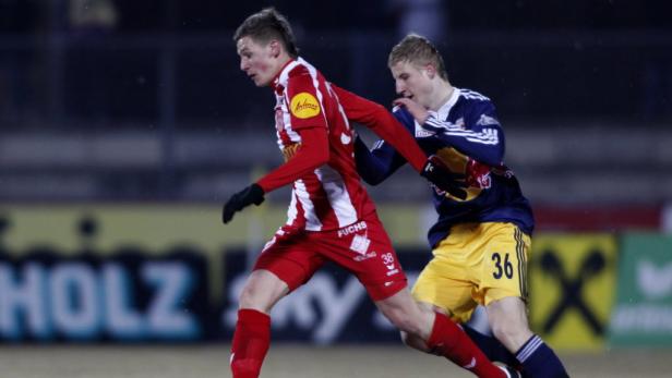 Zwei Fußballspieler kämpfen um den Ball während eines Spiels.