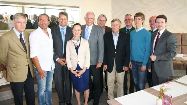 Eine Gruppe von zehn Personen posiert für ein Gruppenfoto in einem Innenraum.