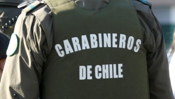 Die Rückseite einer olivgrünen Uniform mit der Aufschrift „Carabineros de Chile“.