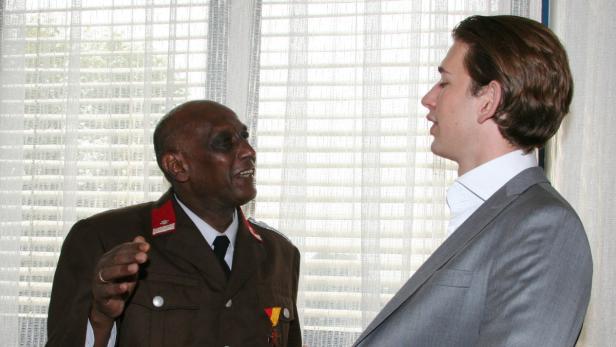 Ein Mann in Uniform spricht mit einem Mann im Anzug.