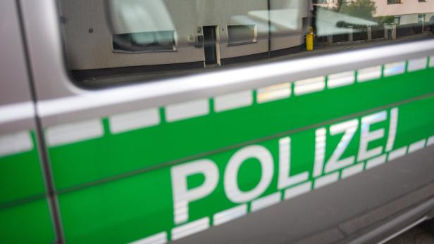 Detailansicht der Aufschrift „Polizei“ auf einem Streifenwagen.