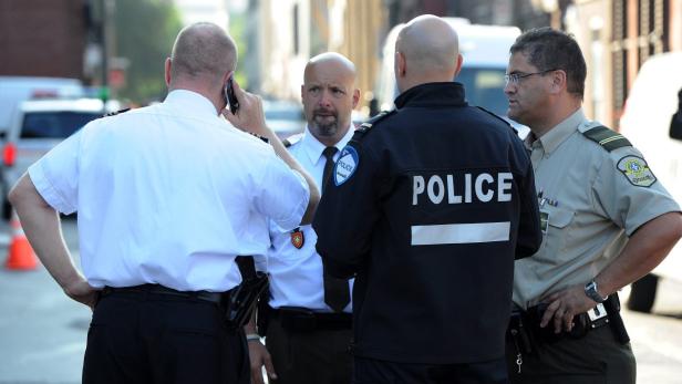 Eine Gruppe Polizisten steht auf einer Straße und unterhält sich.