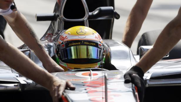 Ein Formel-1-Rennwagen wird von mehreren Mechanikern umgeben.