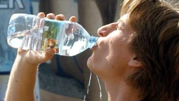 Ein Mann trinkt aus einer Plastikwasserflasche.