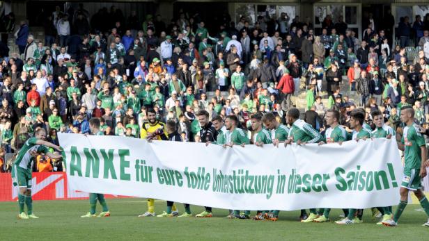 Eine Fußballmannschaft hält ein Banner mit der Aufschrift „Danke für eure tolle Unterstützung in dieser Saison!“.