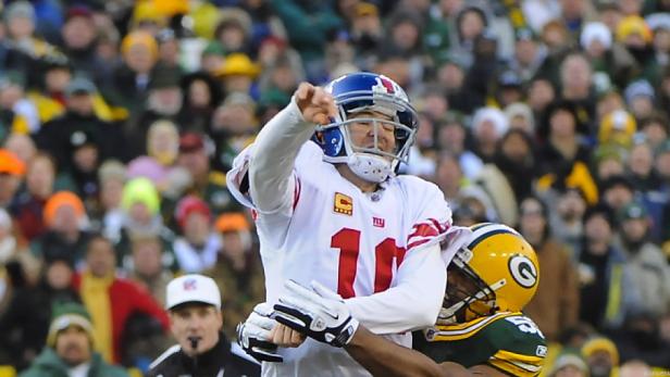 Ein Footballspieler der New York Giants wird von einem Spieler der Green Bay Packers angegangen.