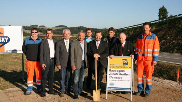 Eine Gruppe von Personen posiert für ein Foto beim Spatenstich für den Ausbau der Landesstraße B 27 in Kleinsteg.